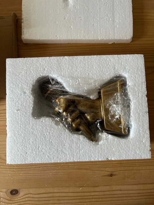 Trofeu mão com microfone dourado
