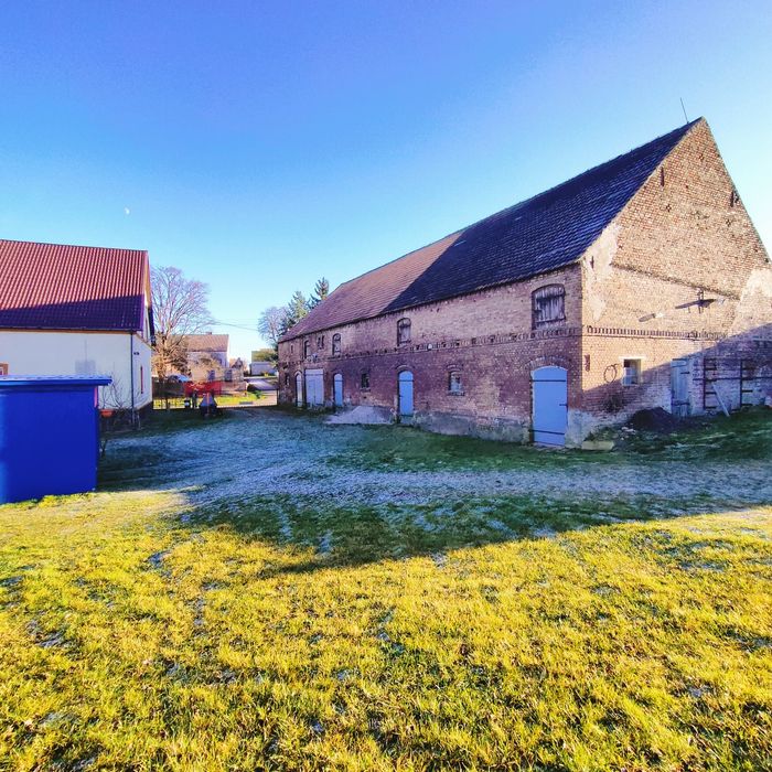 Dom na wsi z dużym budynkiem gospodarczym