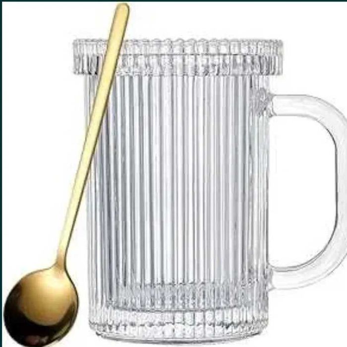 Szklany kubek ze szklana pokrywką i łyżeczka ze stali nierdzewnej