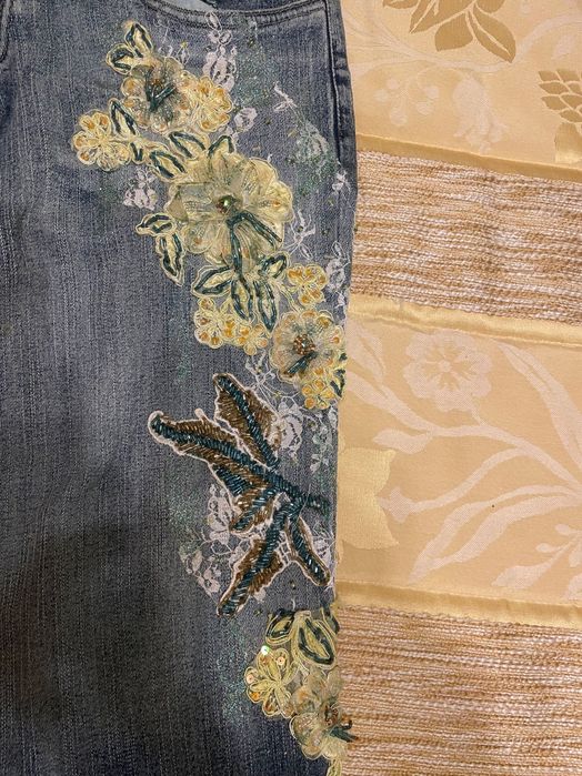 Calças de ganga com bordado em tons de amarelo