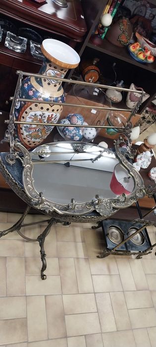 Base para guarda chuvas e espelho de parede com bengaleiro e chapeleiro. Em latão.Mesa meia lua.