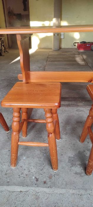 Stół drewniany z 2 krzesłami i 2 stołkami.
