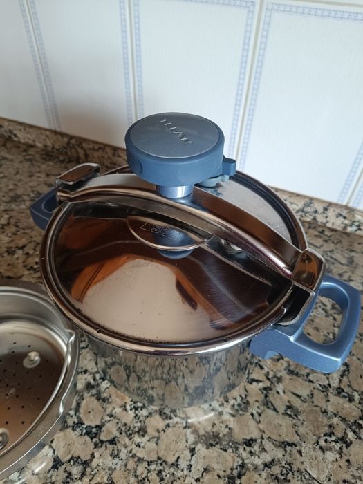 Vendo panela de pressão em aço inoxidável, com tampa original e cesto perfurado para cozinhar a vapor. Possui pegas laterais azuis  está em bom estado