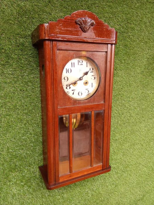 Relógio de parede antigo a funcionar, com chave