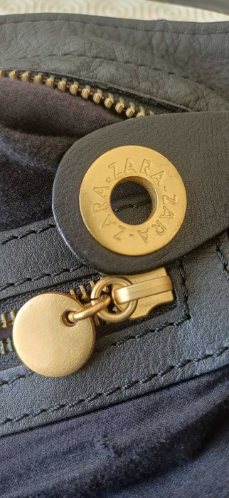 Mala preta em pele com tachas douradas