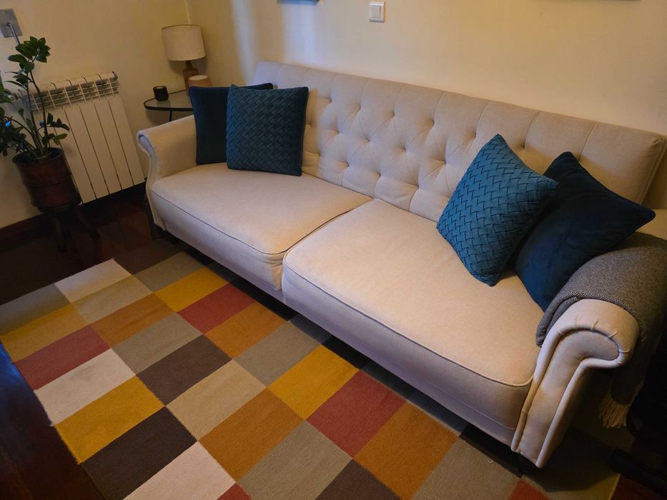 Sofá cama, tapete e almofadas decorativas