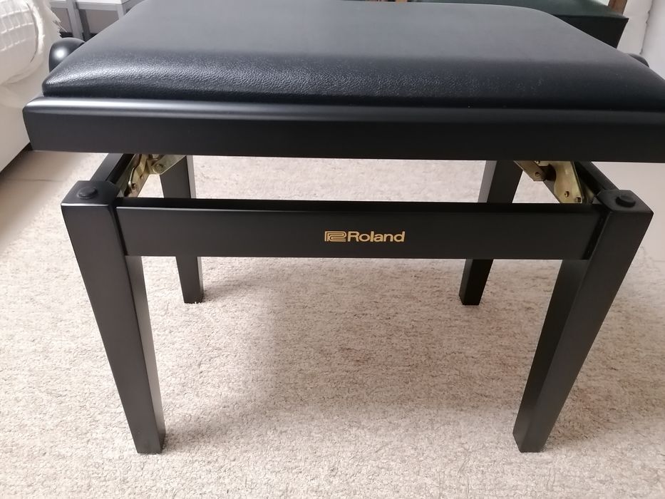 Banco de piano com assento e pele preta.