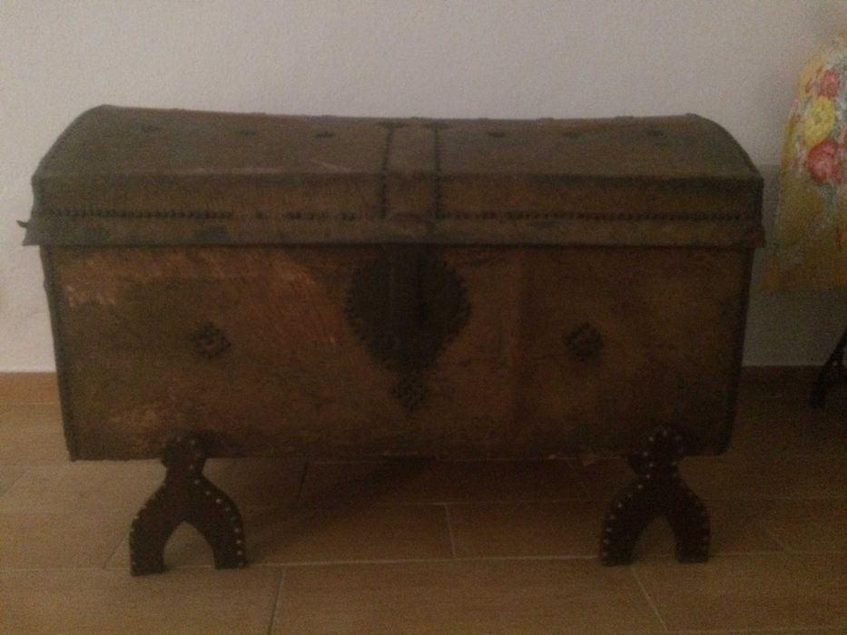 Arca antiga em pele de vaca com pés de madeira