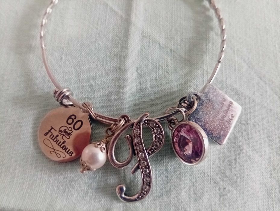 Pulseira em aço inoxidável, com vários berloques temáticos (charm bracelet)