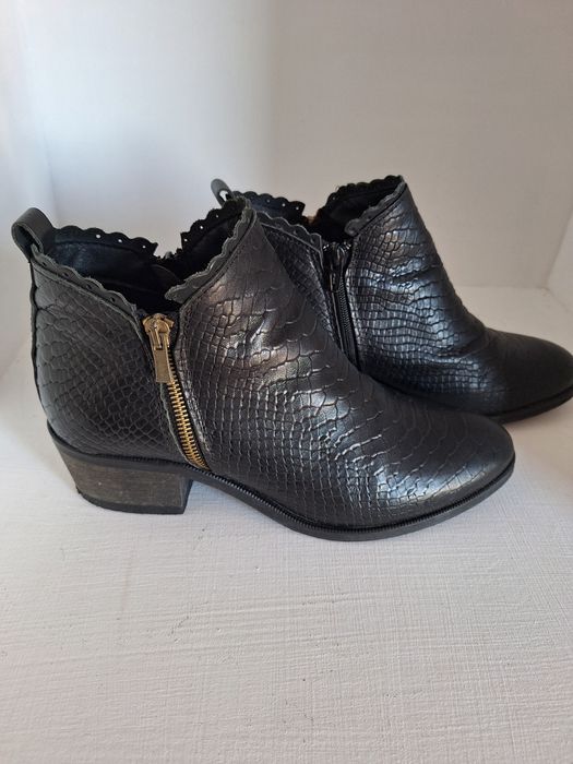 Botas cor preto de salto.