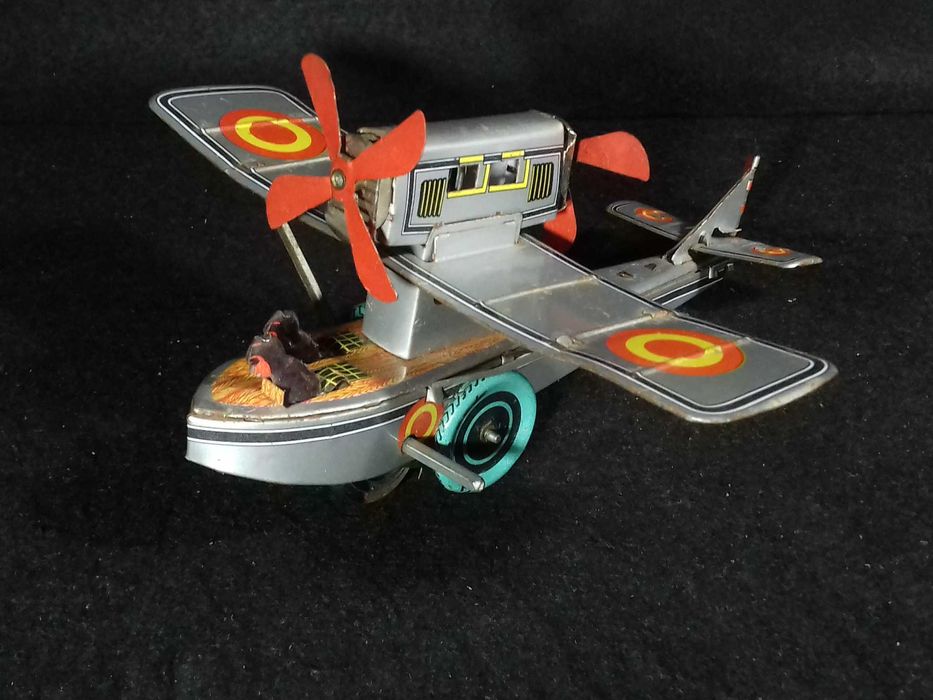 Miniatura de avião antigo em metal, com sistema mecânico de corda;