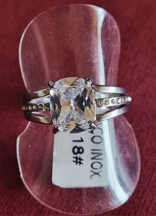 Anel prateado, em aço, com ponto de luz oval e 1 fiada de zirconias.18