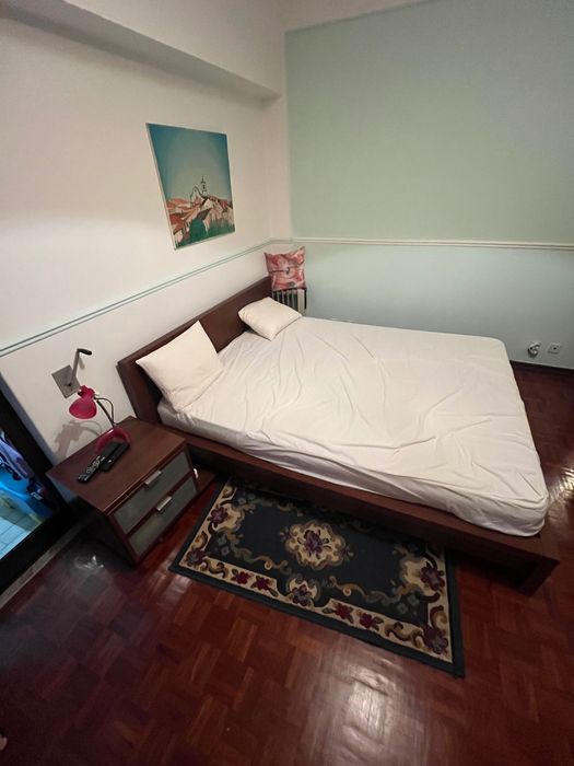 Cama de casal com mesa de cabeceira e apoio