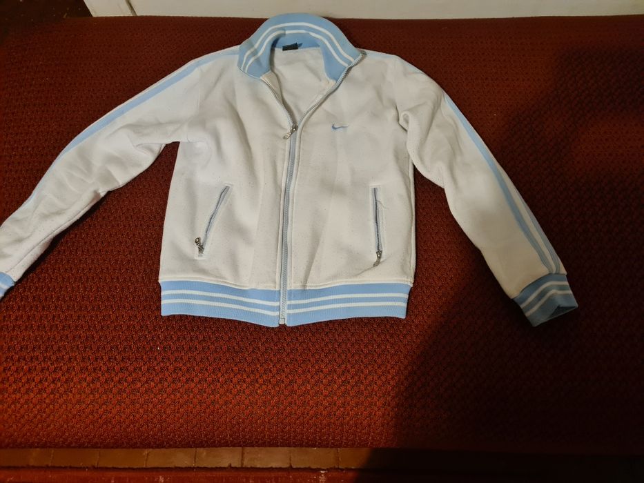 Bluza Nike biała z niebieskimi paskami.