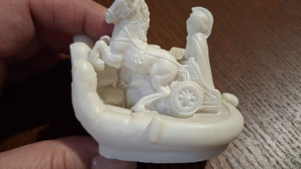 Rzeźbienia figurka rydwan na dłoni.