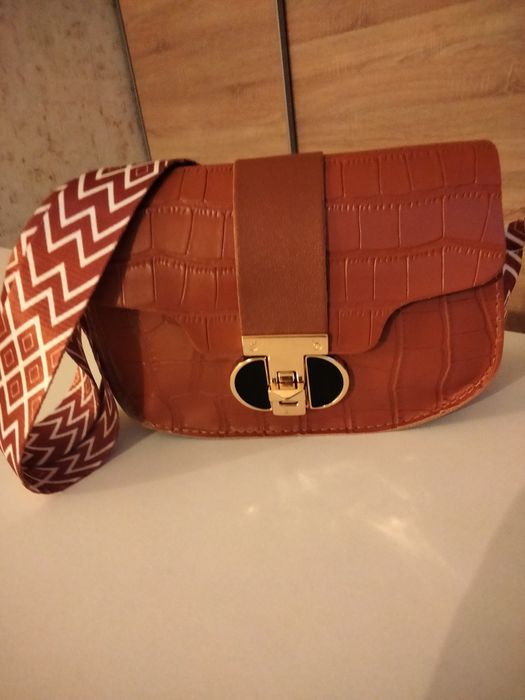 Brązowa torebka typu listonoszka.