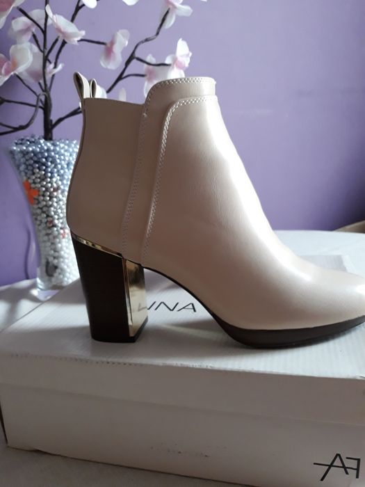 Botki beżowe na słupku.