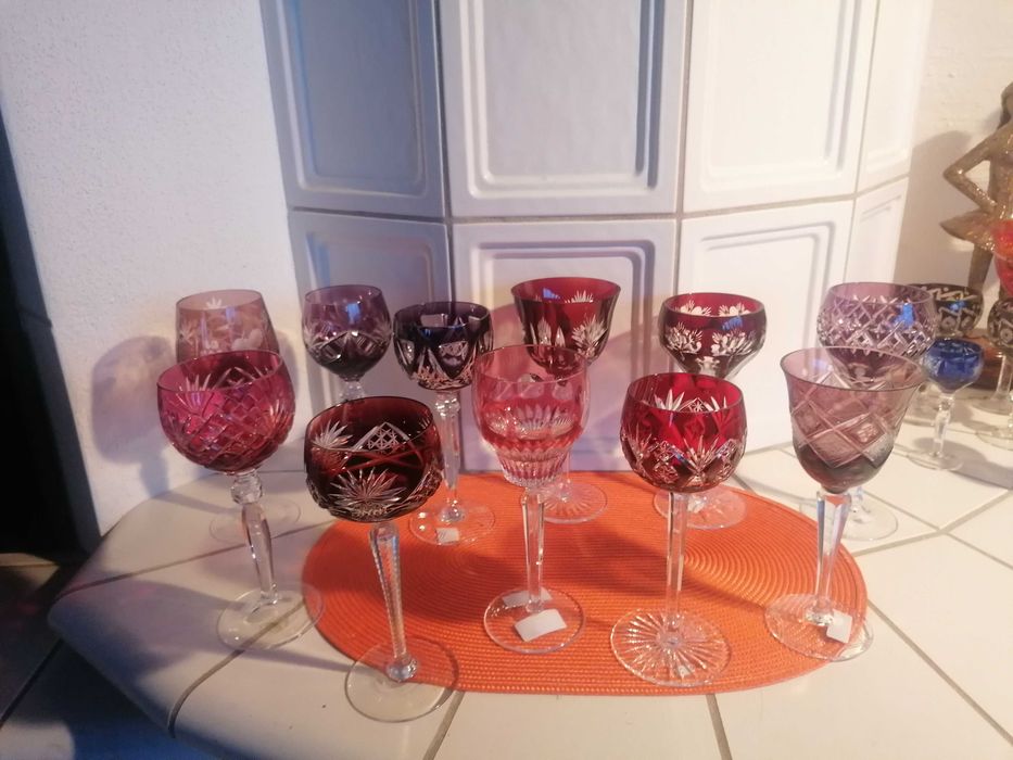 Stare kieliszki kryształowe w odcieniach czerwieni i różu .