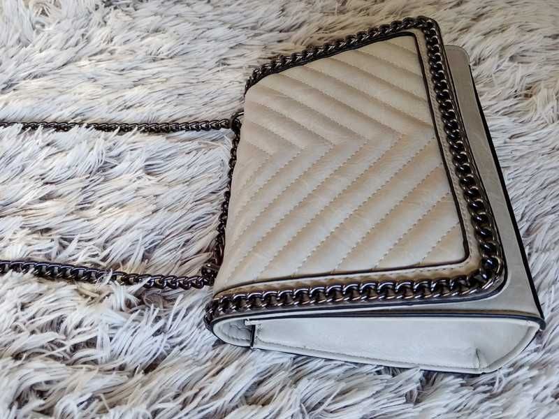 Vendo bolsa tom marfim com alça de corrente preta. Moderna e elegante.
