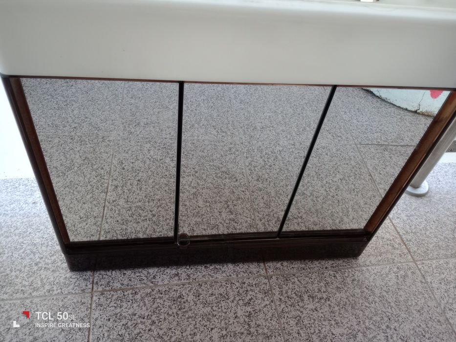 Móvel farmácia de parede em bom estado com três portas e duas gavetas.