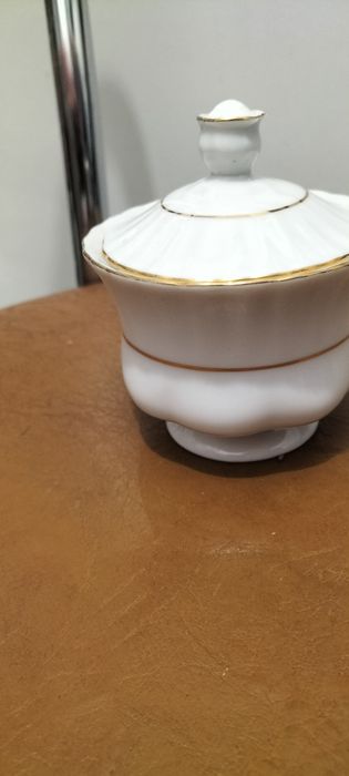 Cukiernica biała ze złotymi paskami. Chodzież