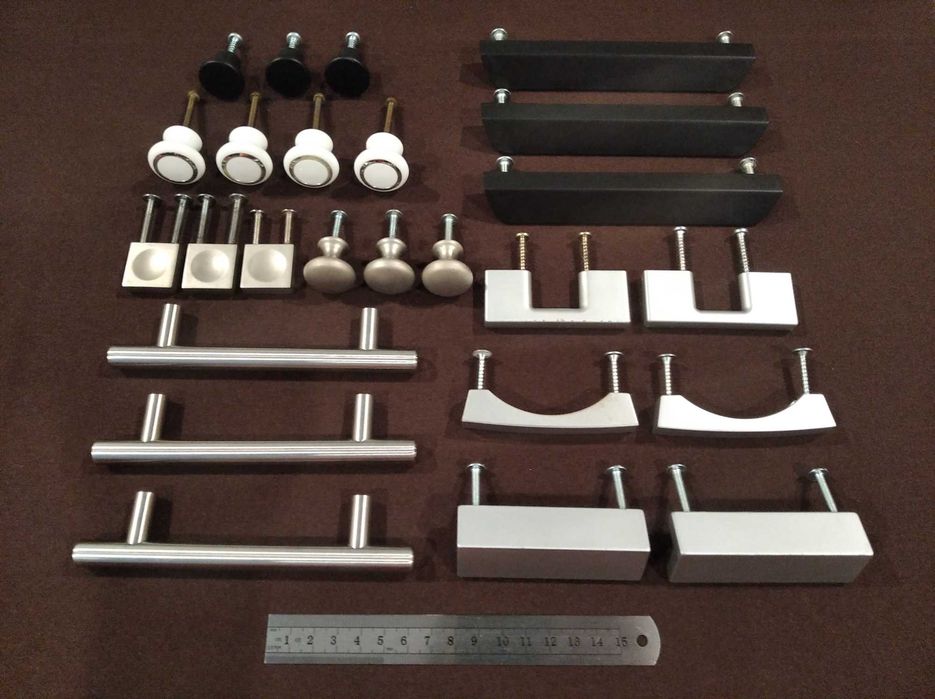 Diversos puxadores para móveis, em metal ou plástico, cores cinza, preto ou branco