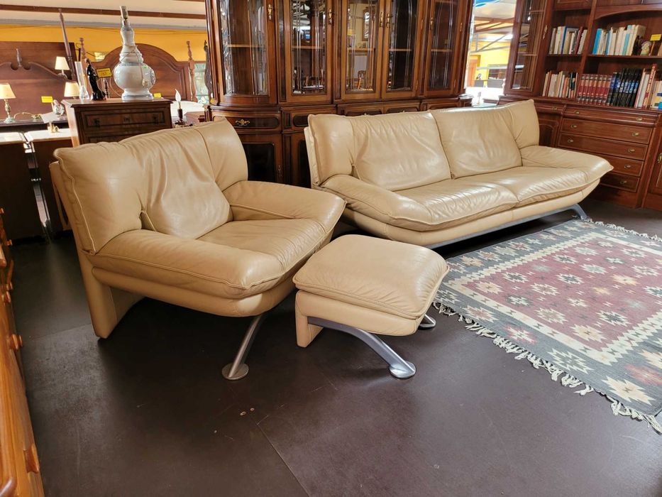 Excelente sofá individual em pele de cor clara com banco de de