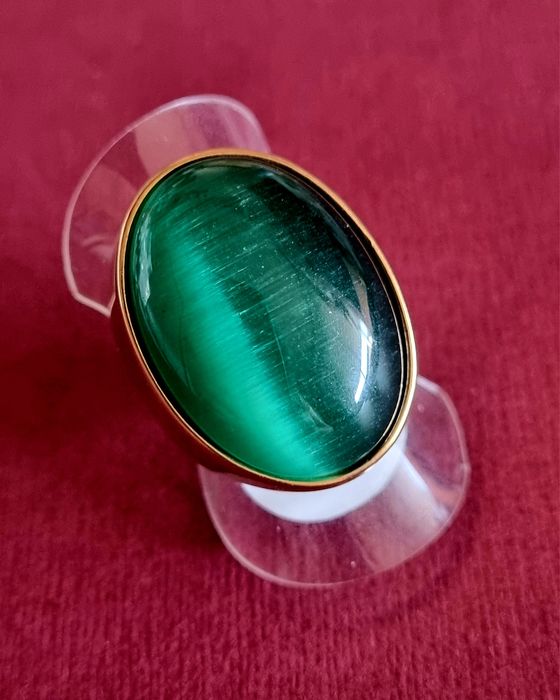 Anel dourado, em aço, com grande pedra verde oval. T17