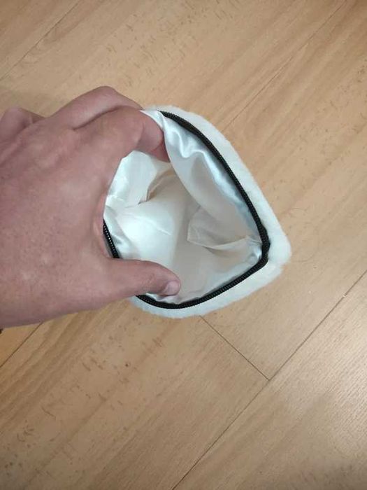 Pequena bolsa de pelúcia branca, frequentemente utilizada como estojo, porta-moedas ou necessaire