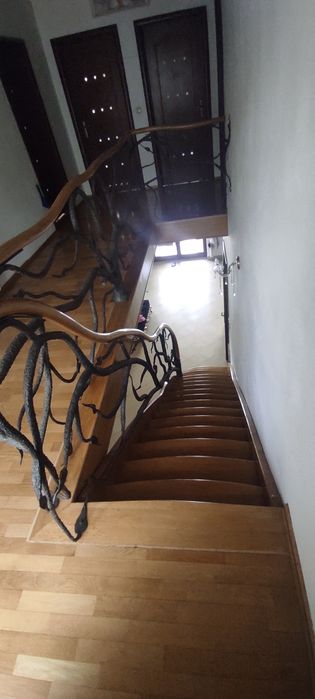 Piękne dębowe schody z kuta barierka i giętą poręczą