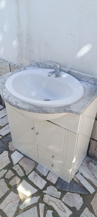 Móvel de casa de banho com lavatório e tampo em mármore.