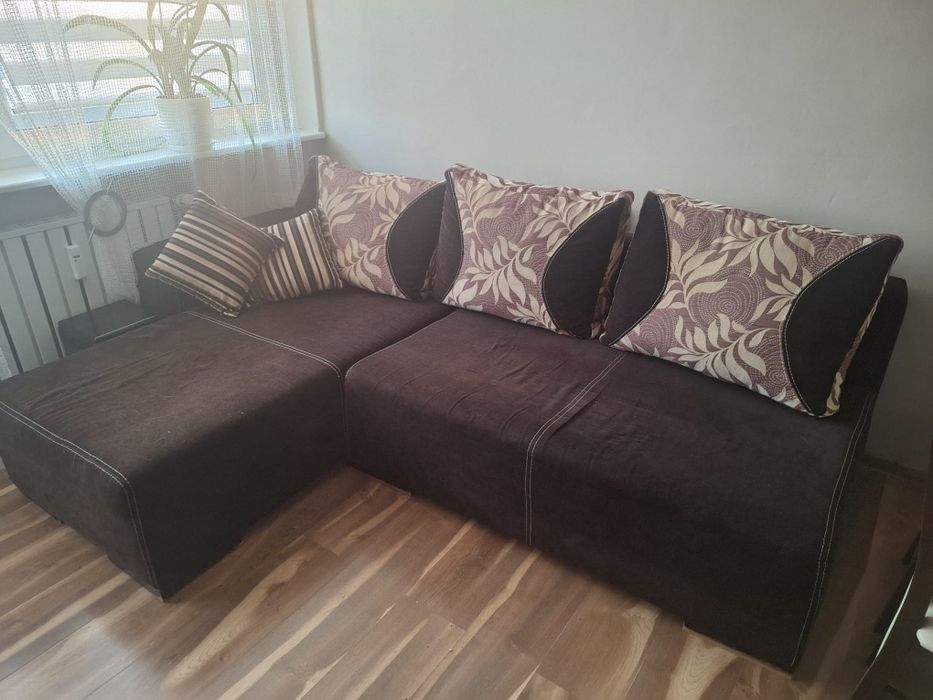 Sofa narożna z poduszkami i szafeczką