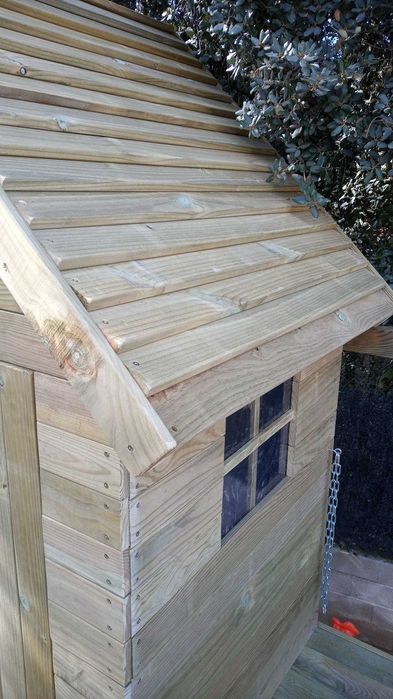 Casinha na árvore com parede de escalada