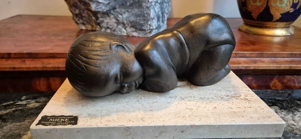 Aukcyjna rzeźba śpiącego dziecka z brązu z ciemną patyną dekor