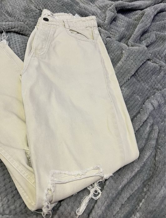 Kremowe mom jeans z przedarciami