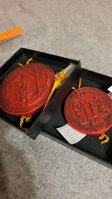 Dwie repliki odcisków pieczęci w wosku.