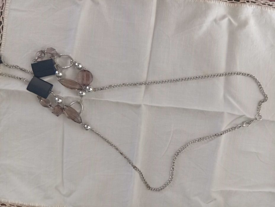 Colar em metal prateado, com aplicações pretas e cinza rosado