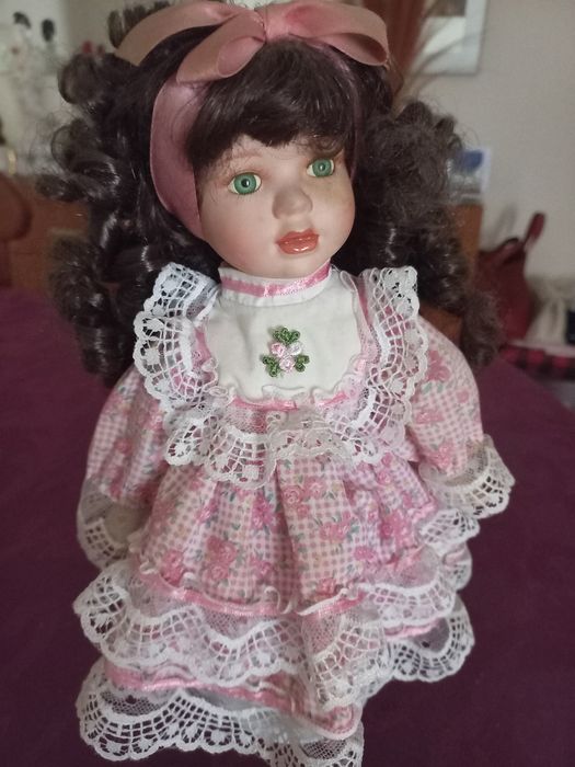 Linda boneca com o rosto em porcelana