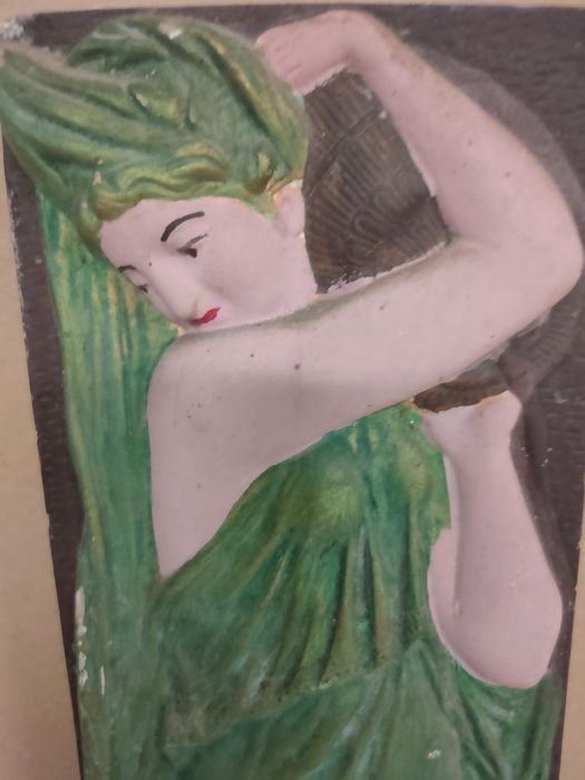 Placa em gesso de figura feminina em relevo.