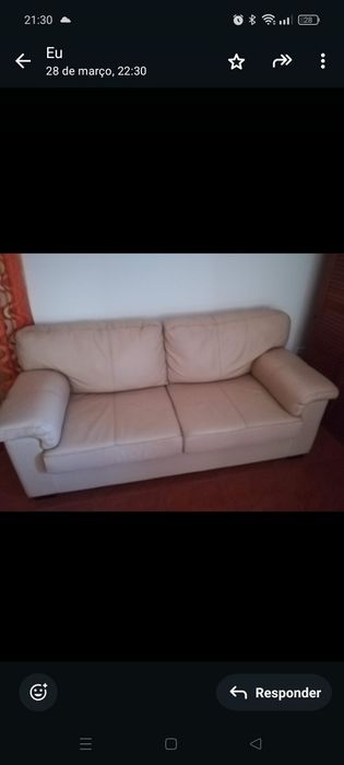 Sofá de três lugares e mesa de centro em vidro