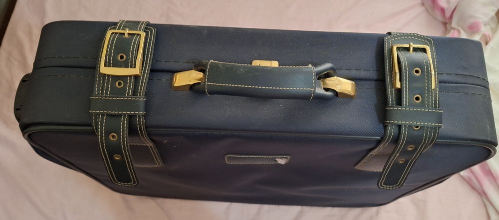 Mala de viagem azul com detalhes dourados