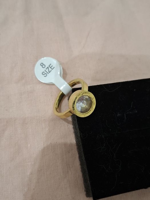 Anel dourado com brilhante e números romanos em Aço Novo