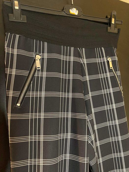 Czarno białe spodnie legginsy w kratkę z suwakami śliskie Stradivarius