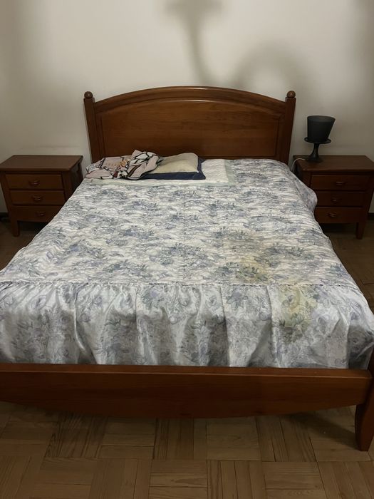 Cama de casal com mesinhas de cabeceira e comoda.