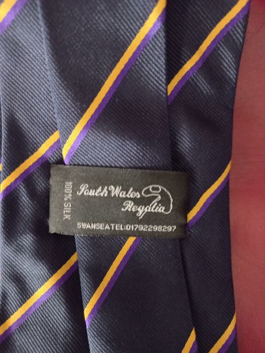 Gravatas novas em seda azul com emblema e riscas dourada e roxo