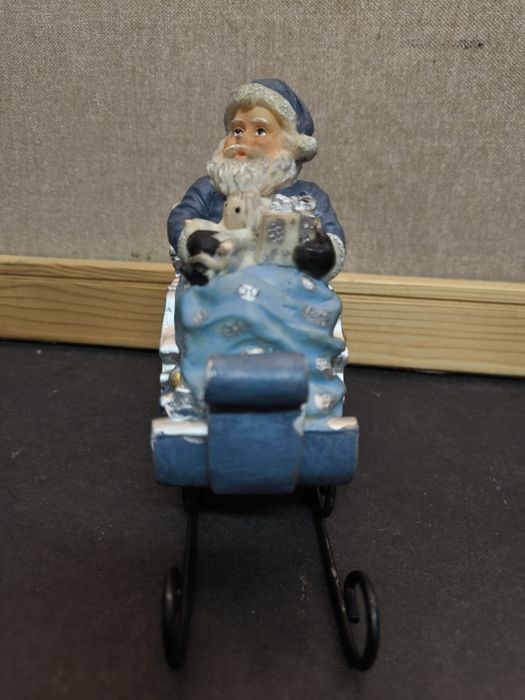 Pai Natal em trenó azul
Figura decorativa de Pai Natal sentado num tre