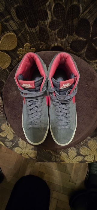 To są szare zamszowe buty Nike Blazer Mid z czerwonymi akcentami.