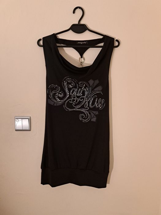 Długą czarną koszulka z łańcuszkiem na plecach.