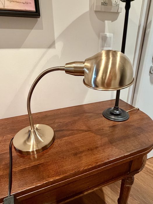 Candeeiro de secretária dourado, elegante e funcional.