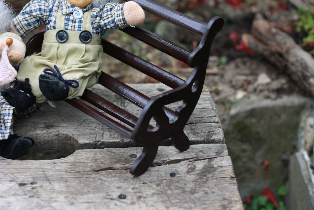 Dwie lalki siedzące na ławce Babcia i Dziadek